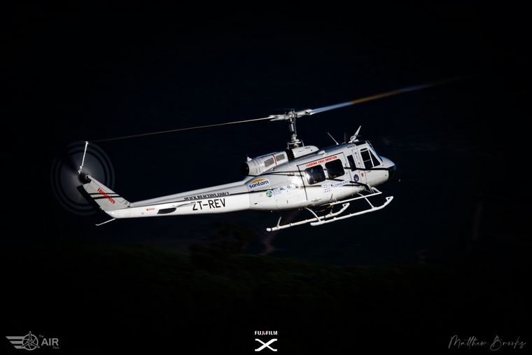 Bell Huey helicopter ZT-REV against a night sky, photograph by Matthew Brooks